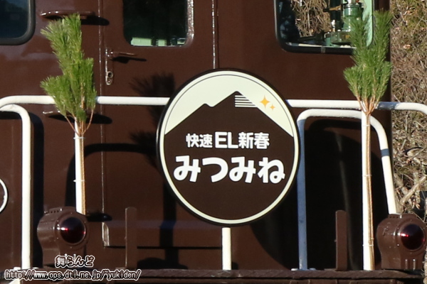 デキ105に付けられた「快速EL新春みつみね」の特別ヘッドマークと正月飾り