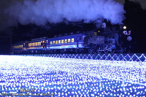 LED照明に照らされた日章旗と謹賀新年のヘッドマークを付けたC11 123が牽引するSL大樹8号