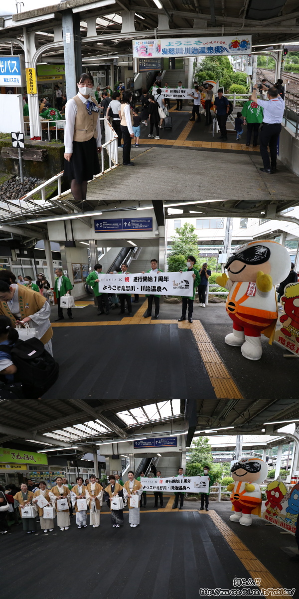 改札口前で記念品を渡す旅館の女将さん達