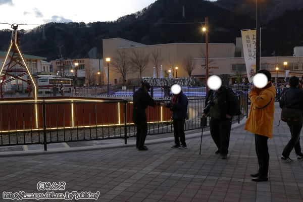 薄暗い駅前広場でシールを配布する鼠小僧（2019-2-16／鬼怒川温泉）