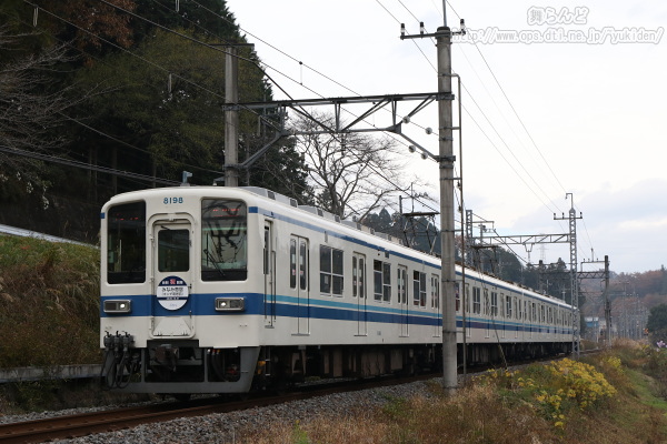 曇天の下を行く新駅開業記念のヘッドマークを付けた8198F